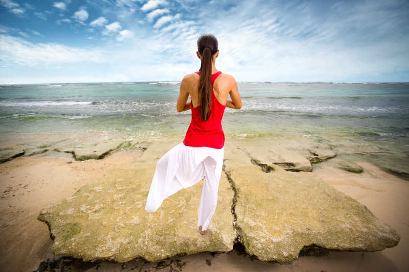 在海边做瑜伽的年轻女人