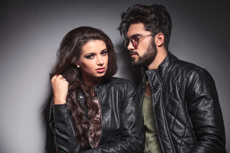 年轻的时尚女人拉她的头发她的情人正看着她