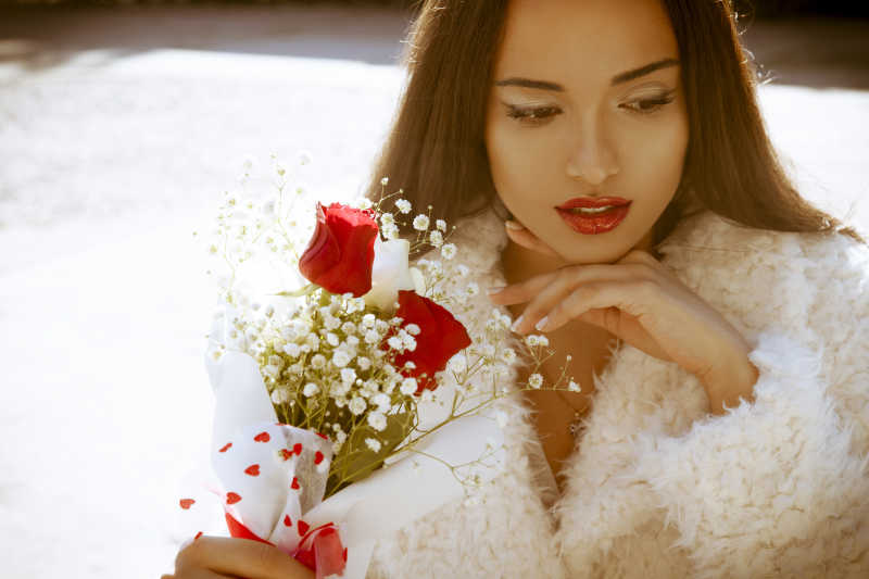 拿着小型玫瑰花束的美女