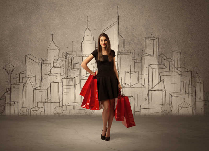 购物女人拿着购物袋站在绘制城市景观前