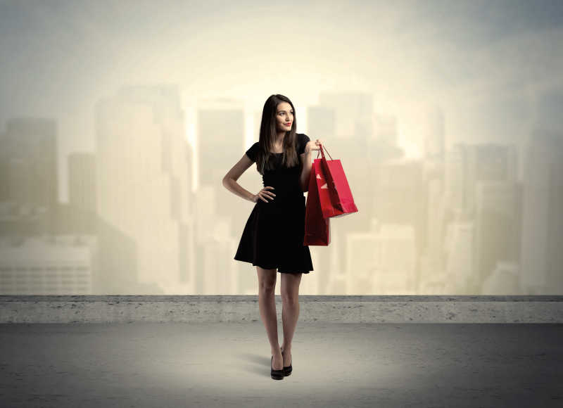 站着购物袋的城市的女人