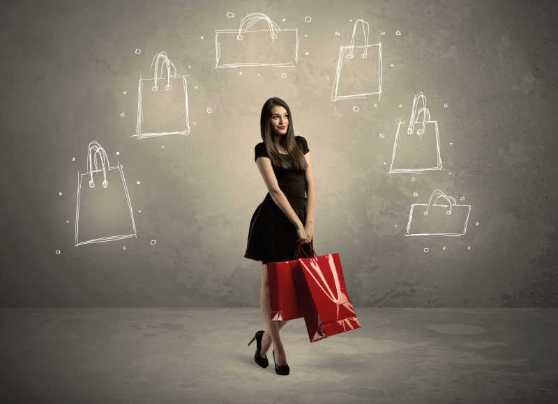墙上有购物袋的购物中心女士拿着红色购物袋