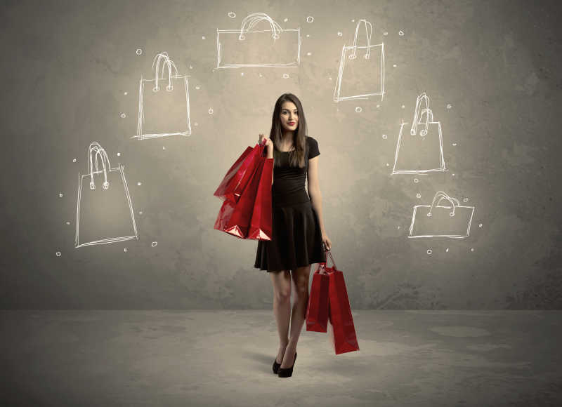 墙上有购物袋的购物中心女士拿着购物袋