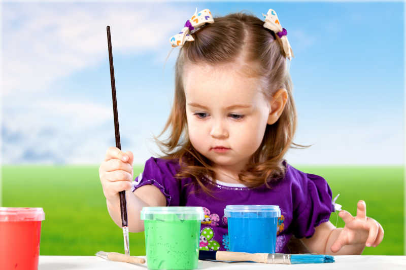 可爱的孩子在玩水彩画