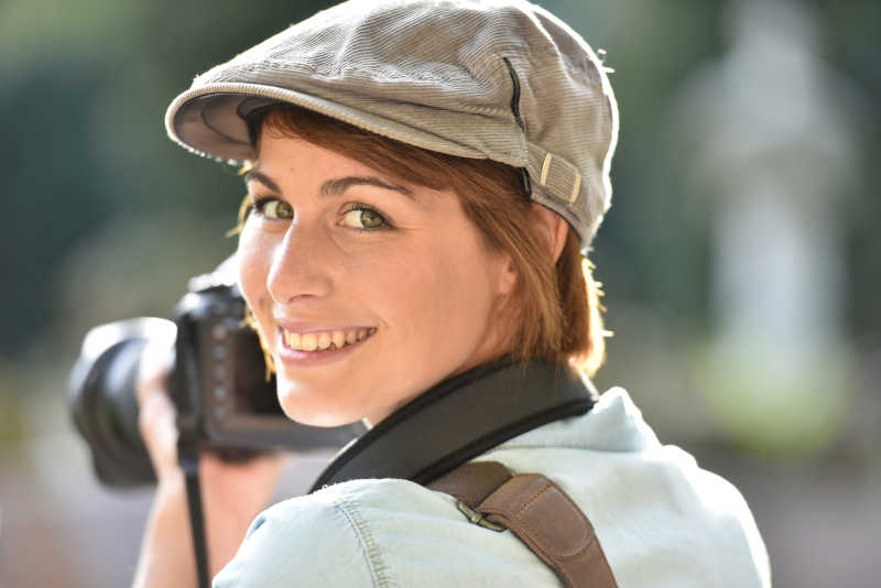 拿着单反相机微笑的女人