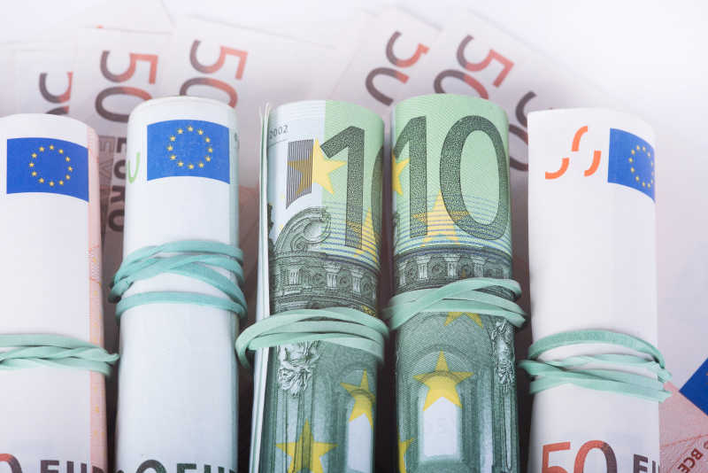50欧元纸币上堆放的卷成卷的不同面值的欧元纸币