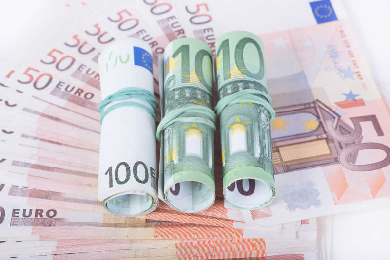 在许多50欧元面值上的3张卷成卷的100欧元