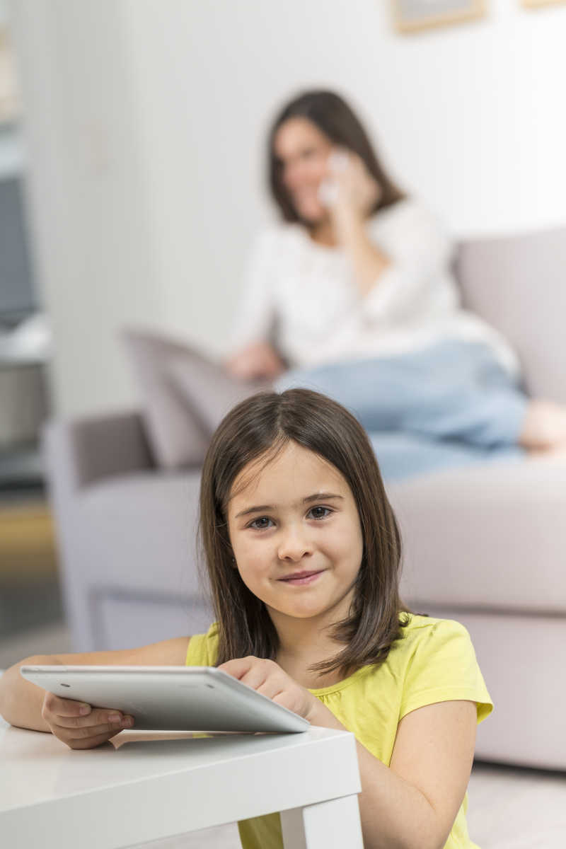 在茶几上玩ipad的女孩