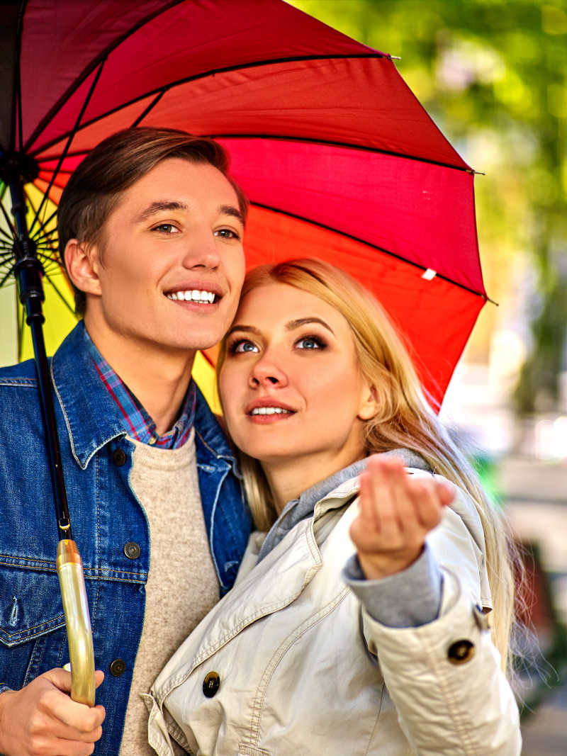 伞下幸福拥抱的年轻情侣