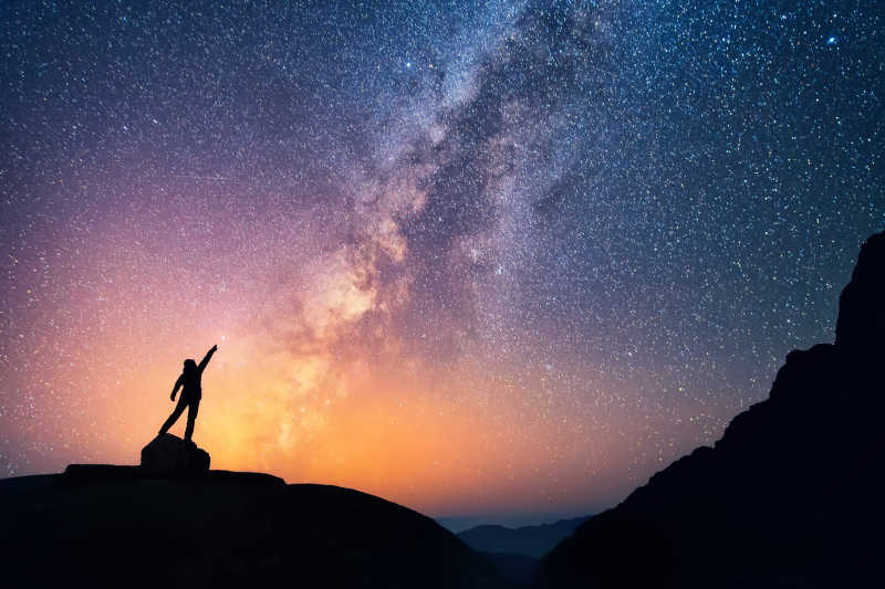 一个人站在山顶观望夜空