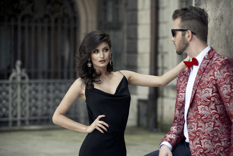 穿着优雅的男士和性感的女人互相对视