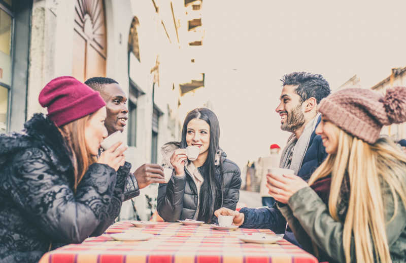 一群不同种族的朋友坐在咖啡厅喝咖啡