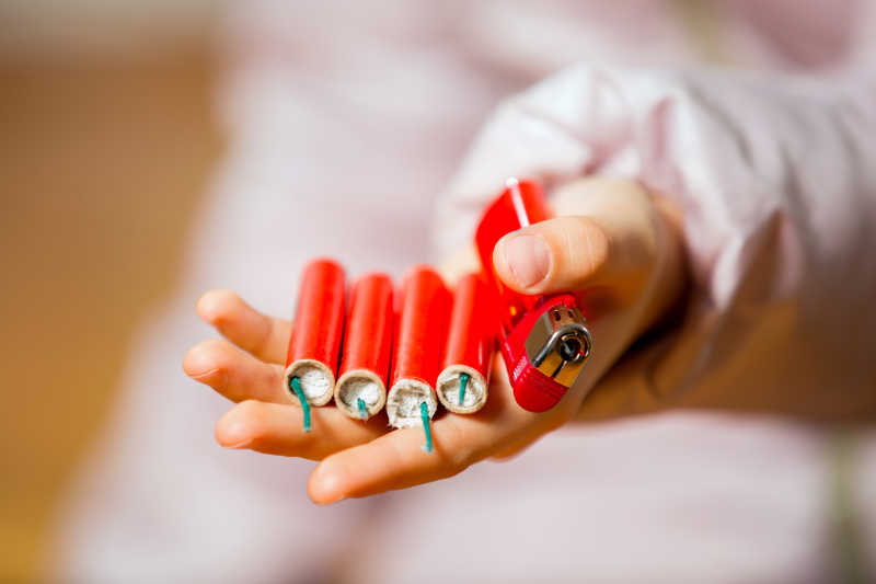 女孩拿在手上的红鞭炮和打火机