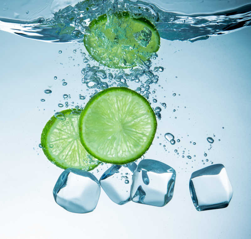 一起落入水中的柠檬片和冰块