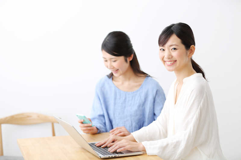 正在使用笔记本电脑的两位亚洲女性
