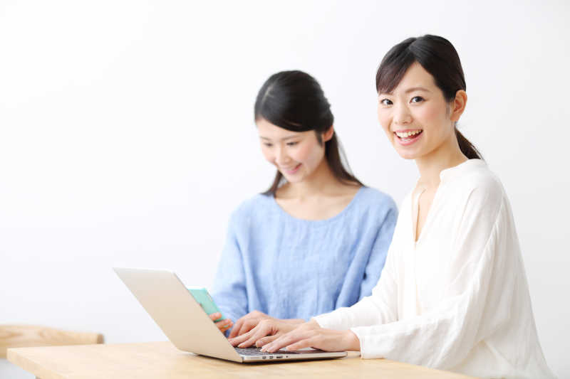 在用笔记本电脑学习的两位年轻美女