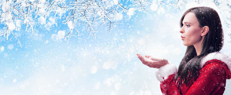 冬日女人吹手中的雪