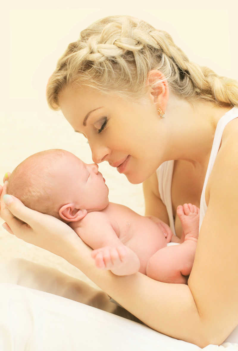 年轻母亲抱着熟睡的婴儿