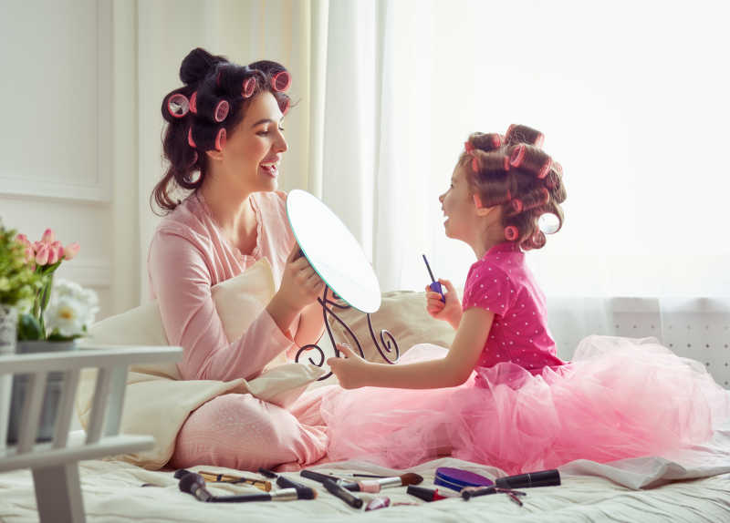 给女儿照镜子的年轻妈妈