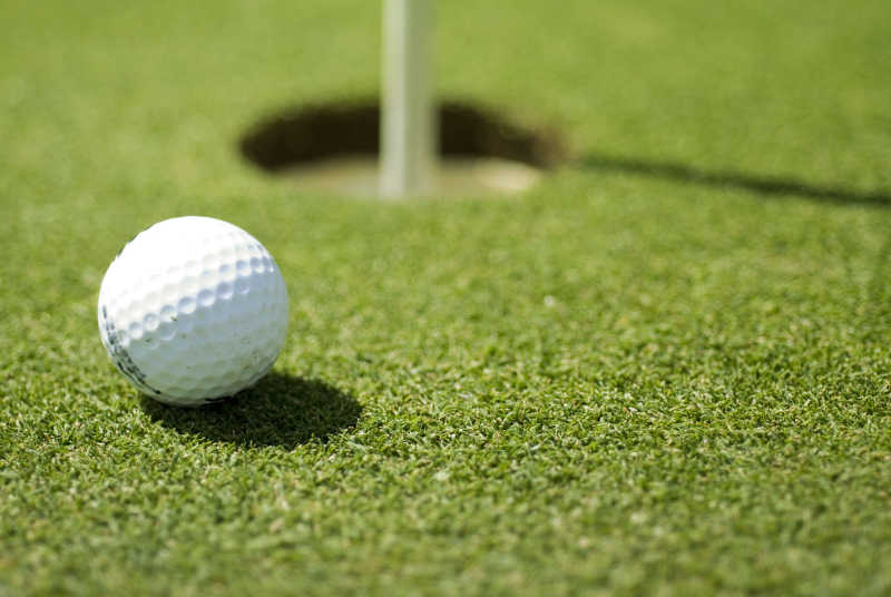 草地上的球洞和高尔夫球