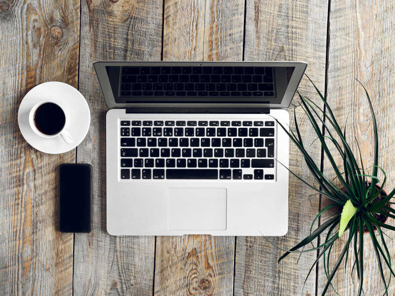 木桌上的笔记本植物和咖啡