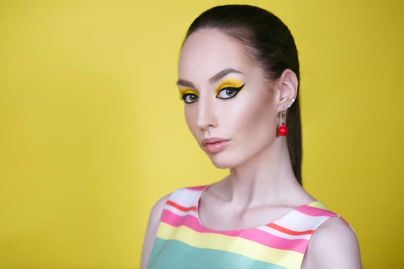 美丽的女人在黄色背景下