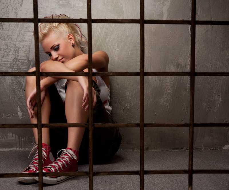 坐在铁围栏后面的朋克女孩