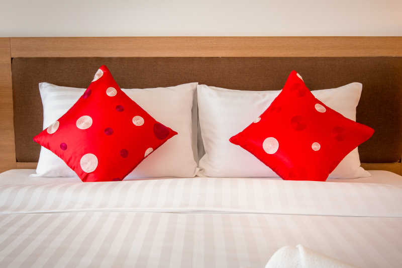 在床上放着两个红色枕头