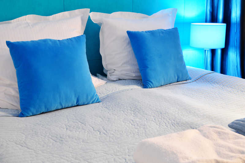 床上放着蓝色和白色的枕头