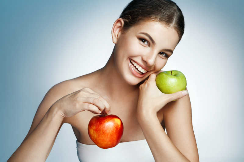 女人拿着两个苹果