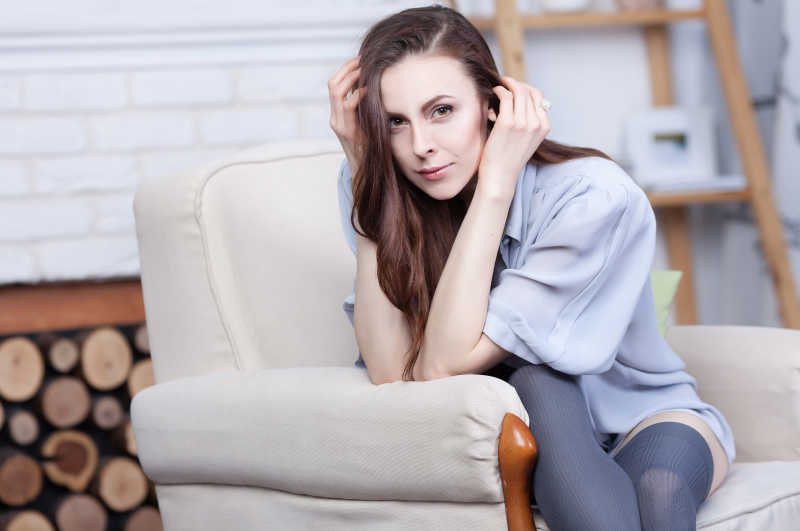 女子坐在壁炉边的椅子上