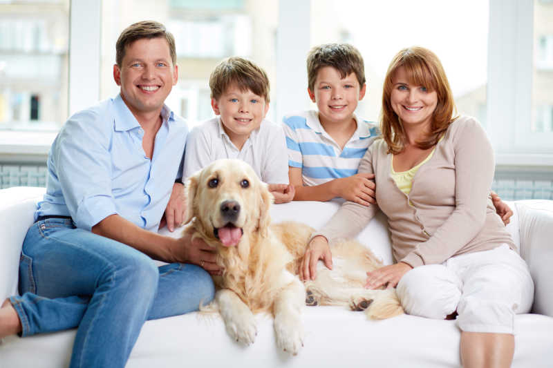 家中有宠物坐在沙发上的快乐家庭