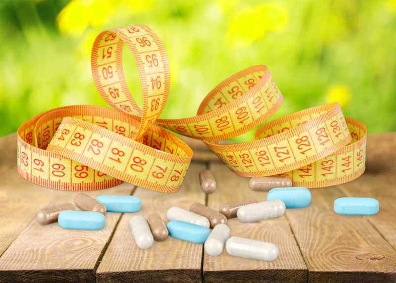 木桌上的胶囊与卷尺