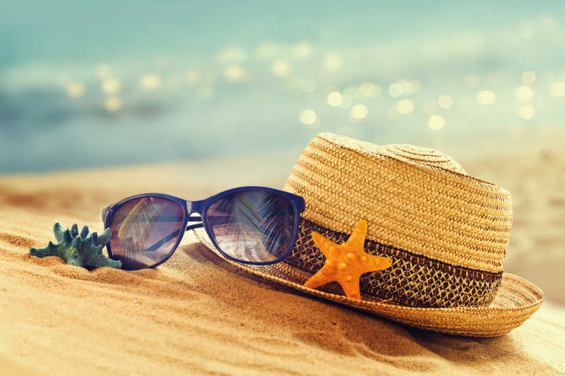 沙滩上的草帽和太阳镜