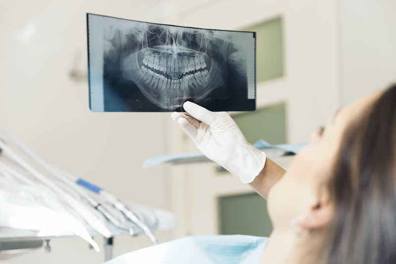 看牙齿射线图交谈的医生与患者