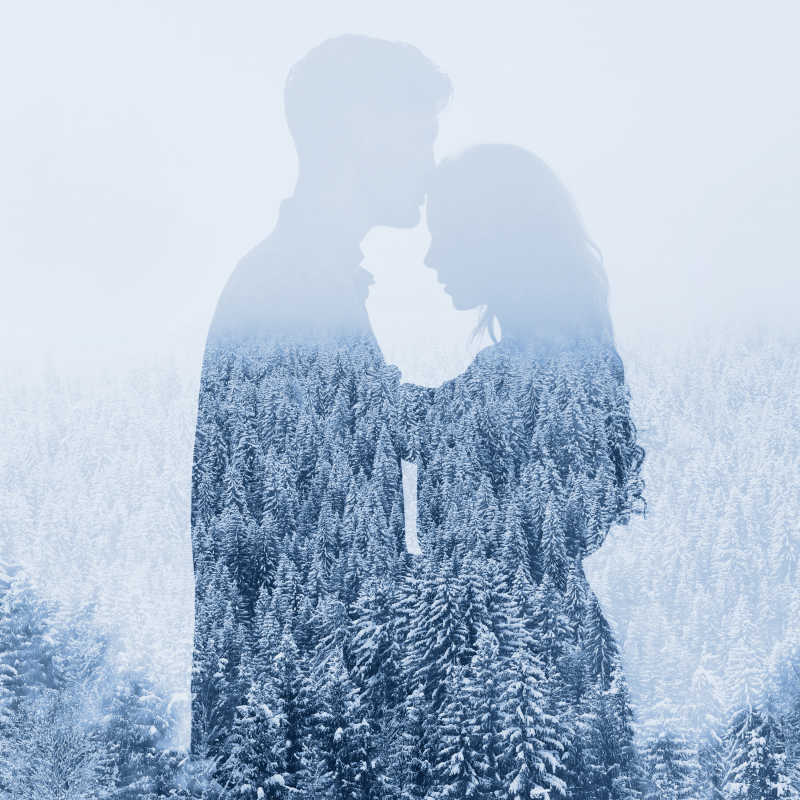 情侣与冬季雪天森林的双重曝光