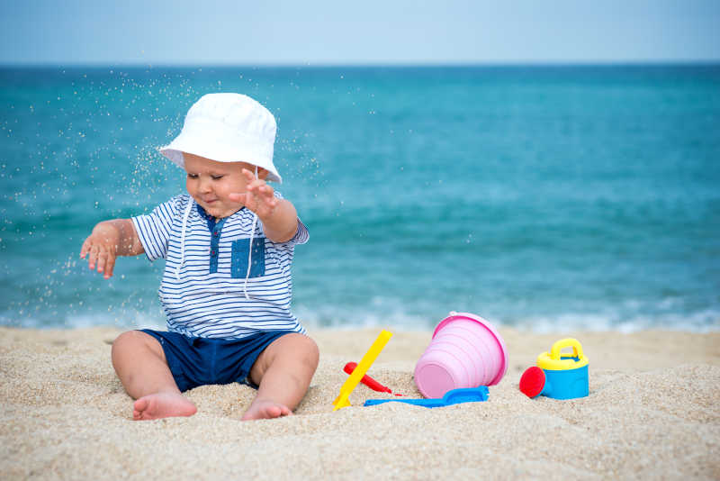 在沙滩上玩玩具的可爱小宝宝
