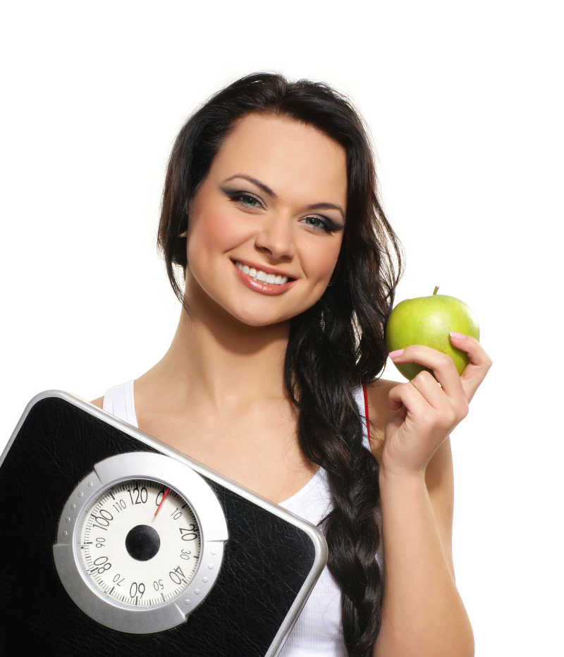 美女微笑着拿着苹果和电子秤