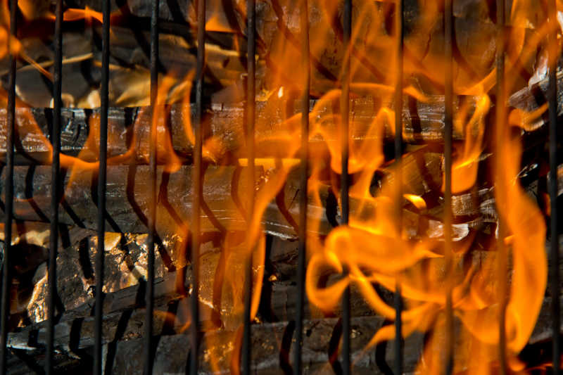 空焰木炭烧烤与火在黑色背景上的特写的火焰