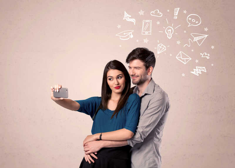 一对年轻夫妇在吸引媒体传播图标上面进行自拍