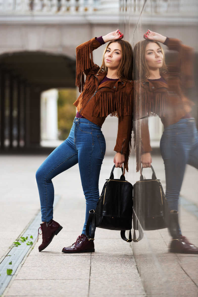 街边领着包自信地摆出动作的年轻女子