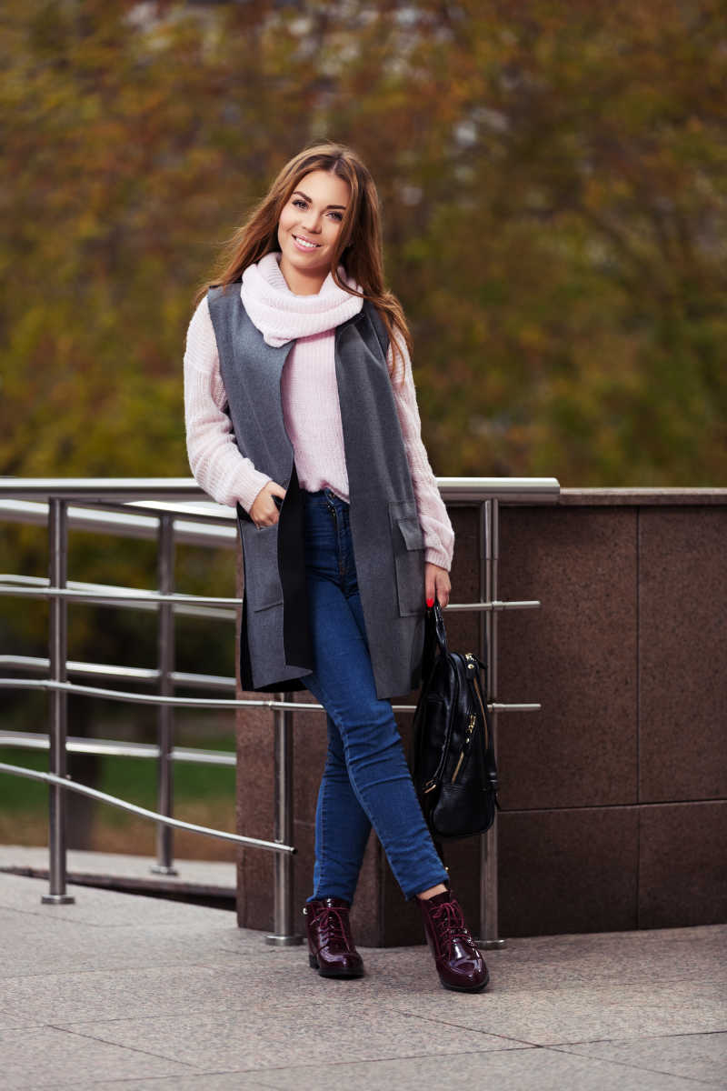 街上穿灰色外套的年轻时尚的长发女子