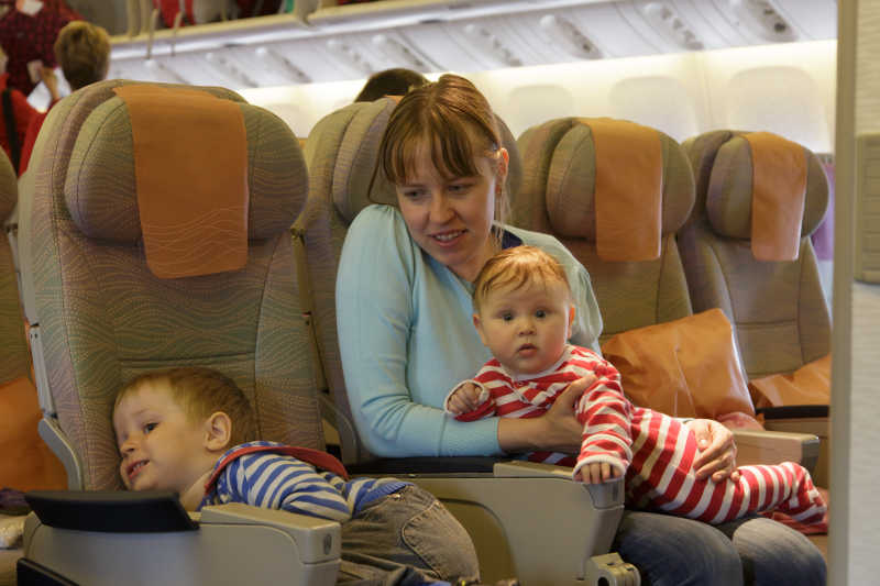 飞机上带着两个孩子的母亲