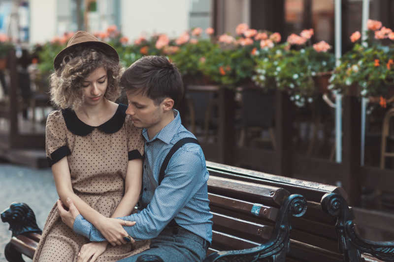 坐在长凳上的恩爱情侣