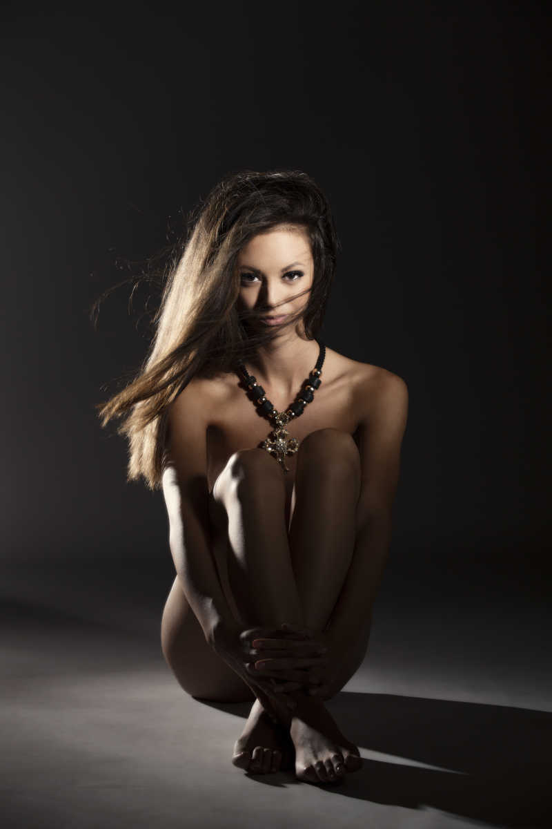 工作室里盘坐拍摄裸体的女孩