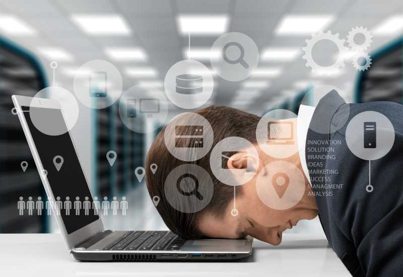 倒在电脑上休息的中年男子