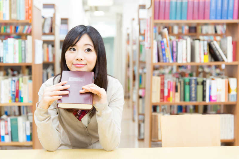 图书馆里拿着书的女学生