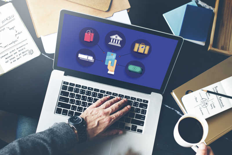 端着咖啡操作电脑的商人