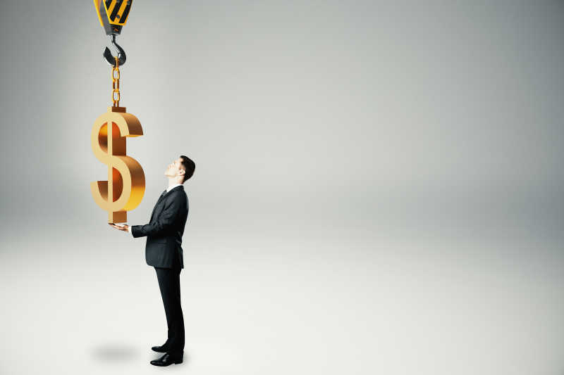 商人将美元样式的挂件挂在吊机挂勾上