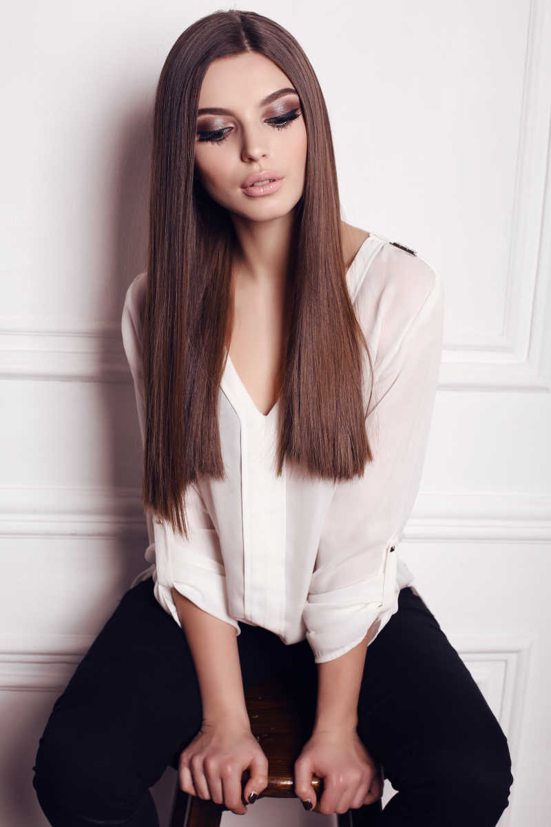 长黑发和美丽的妆容的美丽年轻女子